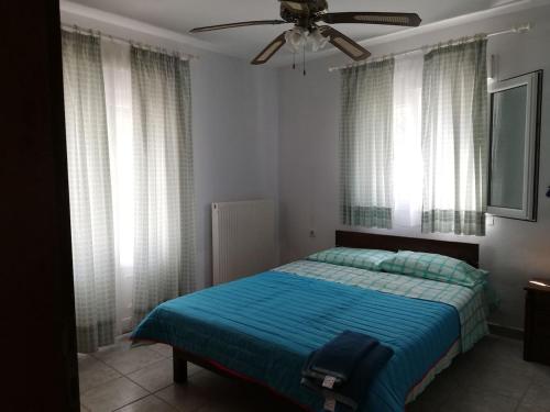 a bedroom with a bed and a ceiling fan at Don Bazilio Seahouse in Leptokaria