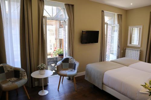 a hotel room with a bed and two windows at VÍA XIX in Caldas de Reis