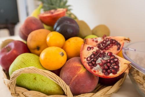 a basket of fruit with pomegranates and other fruits at Dimora San Quirico - bed e breakfast - Cisternino in Cisternino