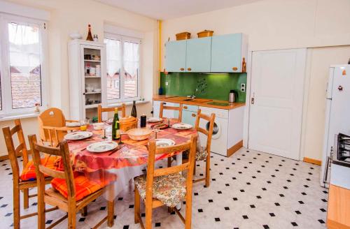 a kitchen with a table and chairs and a refrigerator at "Chez Michele & Christian " in Barr