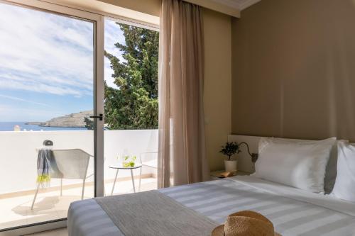 A bed or beds in a room at Lindos Village Resort & Spa - Adults Only