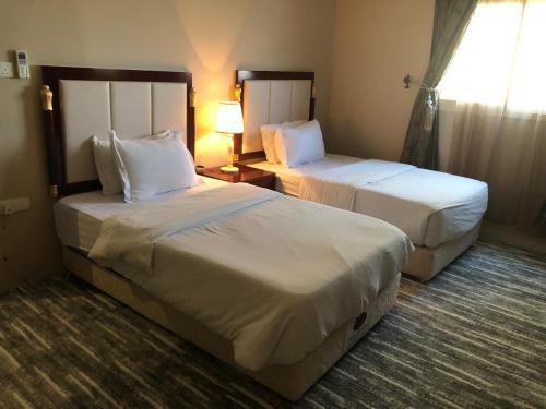 a hotel room with two beds and a window at Concord Plaza in Hafr Al Baten