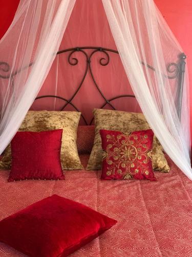 a bedroom with a bed with red pillows at Apartamentos la Jayma del Arte in Asque