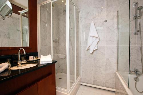 La salle de bains est pourvue d'une douche et d'un lavabo. dans l'établissement Residhome Val d'Europe, à Montévrain