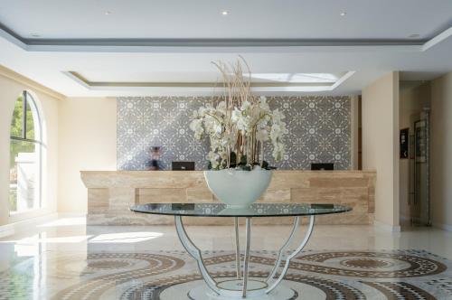 a lobby with a table with a vase on it at Lindos Village Resort & Spa - Adults Only in Líndos