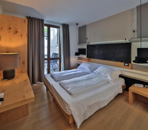 a bedroom with a large bed and a table at Albergo Caffe Centrale in Mezzocorona