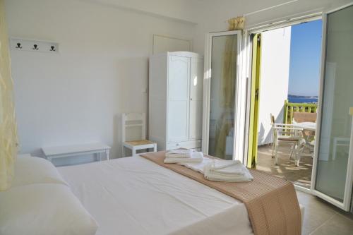a white bedroom with a bed with towels on it at Zeras Apartments in Adamas