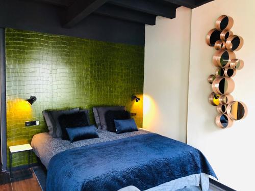a bedroom with a blue bed with a green wall at Hotel de Prince in Nijmegen