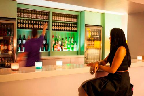 a woman sitting at a counter in a bar at Forshaws Hotel - Blackpool in Blackpool