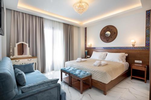 sypialnia z dużym łóżkiem i niebieską kanapą w obiekcie Vener Luxury Suites w Chanii