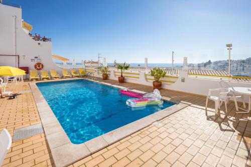 a swimming pool on the roof of a building at Apartamentos Mónaco by Garvetur in Albufeira