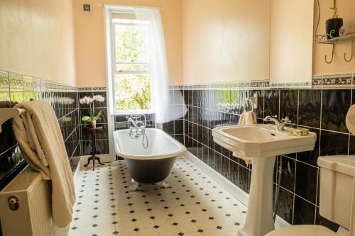 La salle de bains est pourvue d'une baignoire, d'un lavabo et d'une baignoire. dans l'établissement Prince Rupert House at The Red House Estate, à York