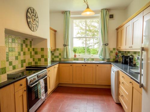 a kitchen with wooden cabinets and a window at Prince Rupert House at The Red House Estate in York