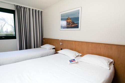 En eller flere senge i et værelse på Hôtel Vert