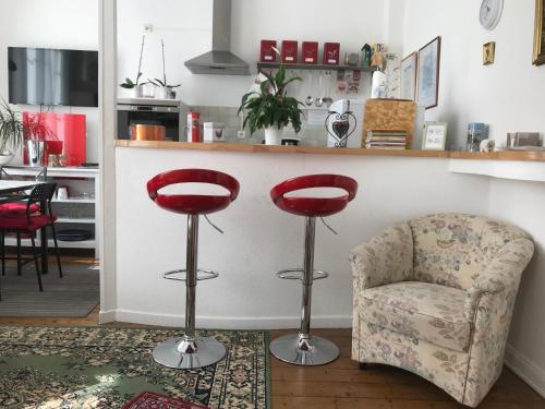 a living room with two stools and a chair at Appartements chez Tante Germaine - Proximité Institutions Européennes in Strasbourg