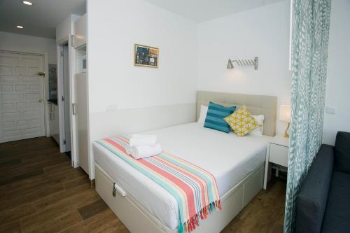 1 dormitorio con 1 cama blanca y 1 sofá azul en MONKÓ LOVELY, QUIET & CENTER SEA VIEWS o, en Torremolinos