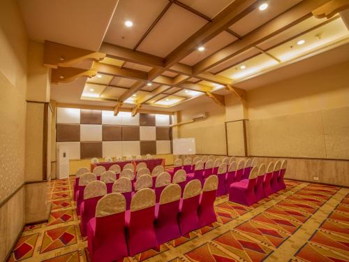an empty room with red chairs in a room at The Orchid Hotel Hinjewadi Pune in Pune
