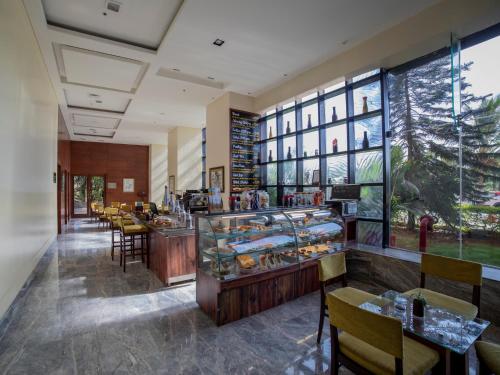 a restaurant with tables and chairs and a display case at The Orchid Hotel Hinjewadi Pune in Pune