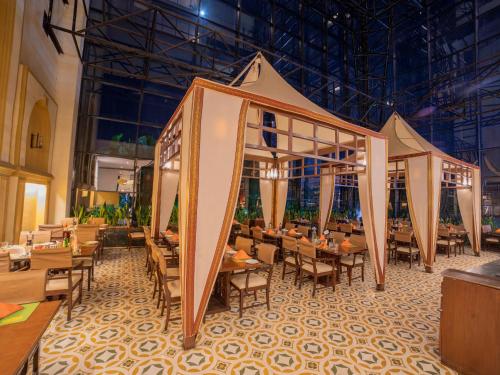 a restaurant with tables and chairs and a tent at The Orchid Hotel Hinjewadi Pune in Pune