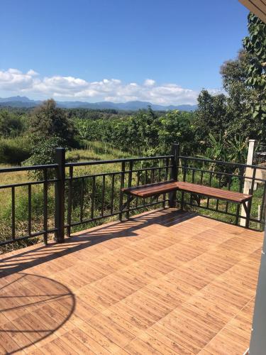 a wooden deck with a bench on a fence at Thungchanghill Resort in Nan