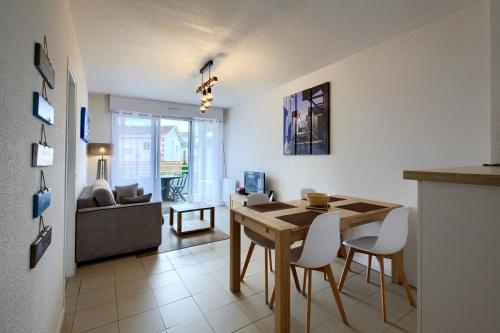 a kitchen and living room with a table and chairs at Appt. Bella Vita - Andernos les Bains, au cœur du Bassin d'Arcachon in Andernos-les-Bains