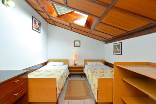 a bedroom with two beds and a skylight at Apartments Fazana 765 in Fažana