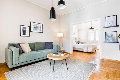 a living room with a green couch and a table at Central Cozy Apartments in Plaka by UPSTREET in Athens