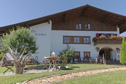 a large white house with a wooden roof at Das Landhaus in Pfronten