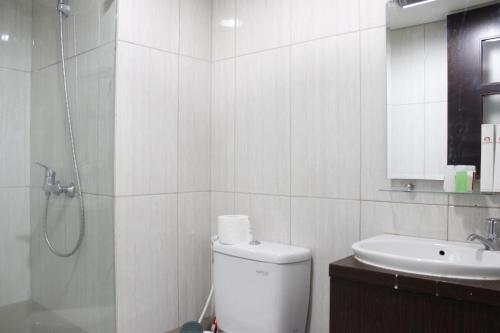 a bathroom with a shower and a toilet and a sink at Bright Studio @ Tamansari La Grande Apartment By Travelio in Bandung