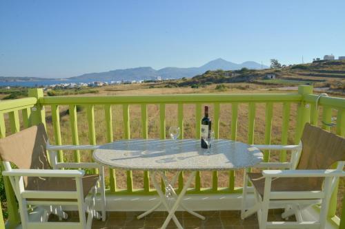 a table with a bottle of wine and two chairs at Zeras Apartments in Adamas