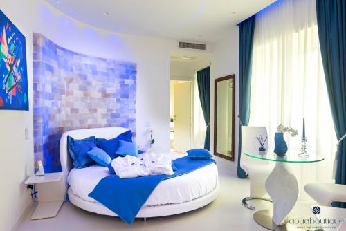 a bedroom with a white bed with blue pillows at Aquaboutique Wellness&Spa in Vietri sul Mare
