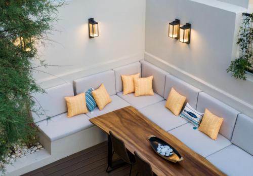 a bench with pillows and a table on a patio at Iris Skiathos in Skiathos Town