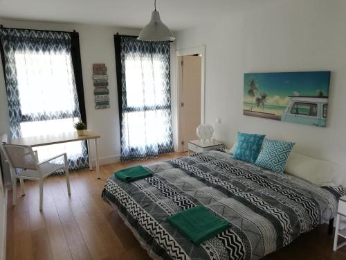 1 Schlafzimmer mit einem Bett, einem Schreibtisch und 2 Fenstern in der Unterkunft LAGA BLUE SURF in Ibarrangelu