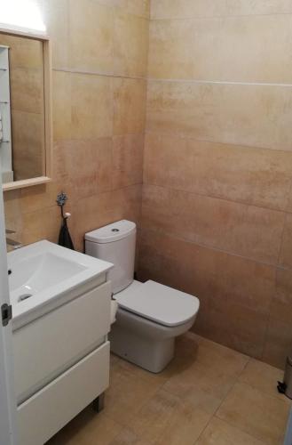 a bathroom with a white toilet and a sink at Laga Blue Surf in Ibarrangelu