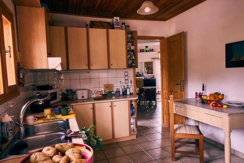 une cuisine avec des armoires en bois, un évier et une table dans l'établissement Estate with amazing views of Poros, à Poros