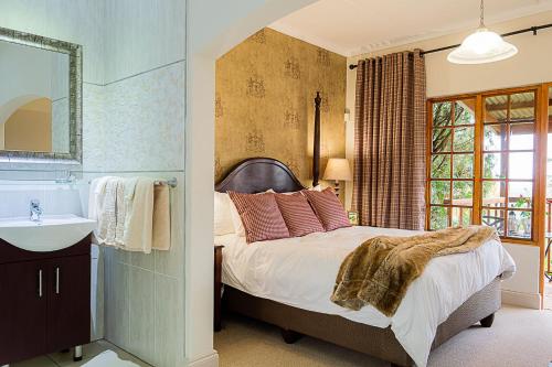 una camera con letto, lavandino e specchio di Glen Ormond Country House a Henburg Park