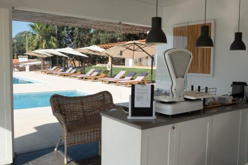 a counter with a mirror and chairs next to a pool at Casas Do Rio Sado - Sado River Country Retreat in Santa Margarida do Sado