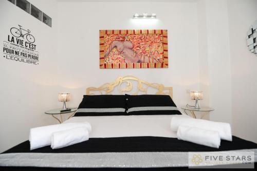 une chambre avec un lit noir et blanc avec deux lampes dans l'établissement Mini Suite Bijou - Five Stars Holiday House, à Nice