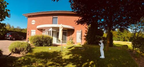 uma estátua em frente a uma casa de tijolos em smart&beautiful Guesthouse em Nordkirchen