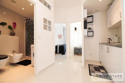 une salle de bain blanche avec des toilettes et un lavabo dans l'établissement Mini Suite Bijou - Five Stars Holiday House, à Nice