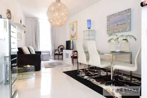 un salon avec une table et des chaises blanches dans l'établissement Mini Suite Bijou - Five Stars Holiday House, à Nice