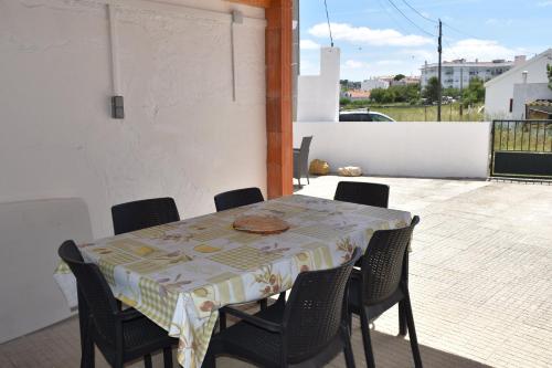 a table with chairs and a table cloth on a patio at Maison D'Almoinha in Sesimbra