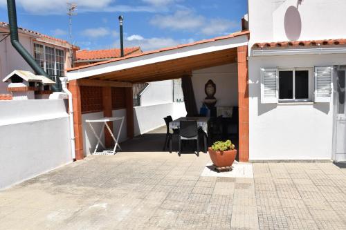 a patio with a white building and a table at Maison D'Almoinha in Sesimbra