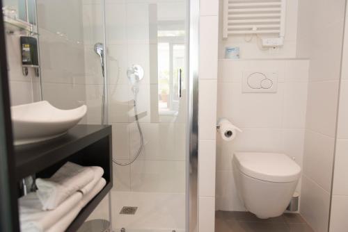 a white bathroom with a toilet and a sink at Hôtel Astoria in Nantes