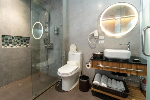 a bathroom with a shower and a toilet and a sink at SureStay Plus Hotel by Best Western AC LUXE Angeles City in Angeles
