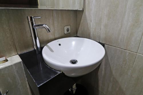 a white sink in a bathroom with a faucet at Hotel Bumi Makmur Indah in Bandung