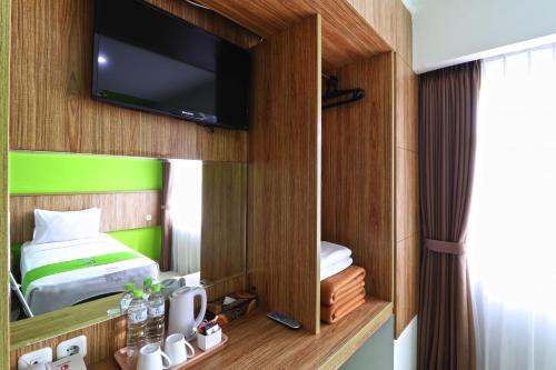 a bedroom with a bed and a tv on a wall at Hotel Bumi Makmur Indah in Bandung