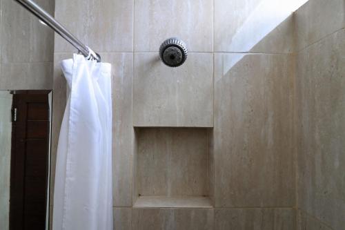 a shower with a white shower curtain in a bathroom at Hotel Bumi Makmur Indah in Bandung