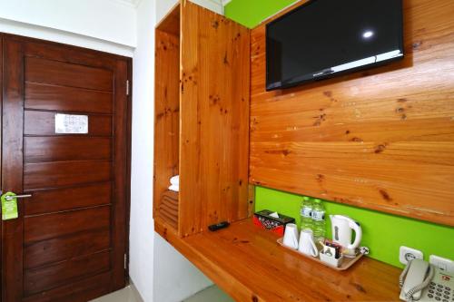 a room with a television on a wooden wall at Hotel Bumi Makmur Indah in Bandung