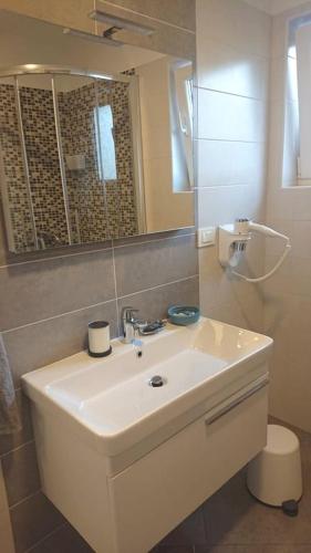 a bathroom with a white sink and a mirror at Apartments Nina in Rab